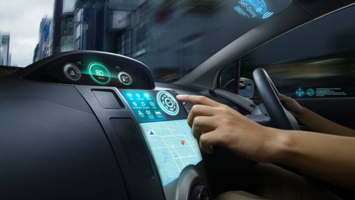 Driver interacting with a futuristic car dashboard featuring touch controls and holographic display, in motion on a blurred city street.
