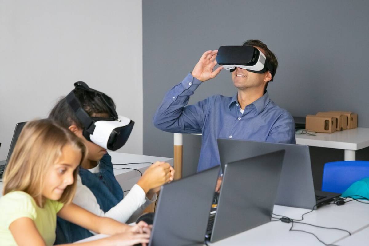 Adult and children using virtual reality headsets at a tech-studded desk.